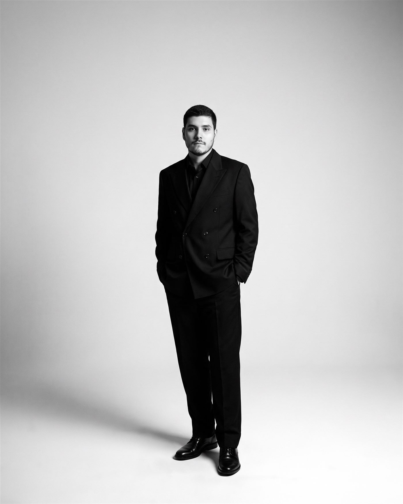 Gabriel Lopes de corpo inteiro, de terno preto
